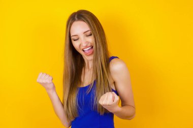 Kafkasyalı esmer kadın başarısını ve zaferini sevinçle kutluyor ve yumruklarını zevkle sıkıyor. Tüylü, şanslı kadın hedefine ve hedeflerine ulaştığına seviniyor. Olumlu duygular, duygular.