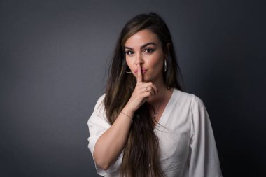Sırrımı söyleme ya da yüksek sesle konuşma, lütfen! Duygusal olarak şaşırmış bir öğrenci sessiz olur, sessiz olur musun diye sorar. Sırrını açıklamaktan korkar ve gri stüdyo duvarına karşı durur..
