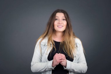 Vay canına. Gri stüdyo arka planında izole edilmiş güzel beyaz kadın portresi. Genç, duygusal, şaşkın bir kadın, ağzı açık duruyor. İnsani duygular, yüz ifadesi kavramı. Moda renkleri.