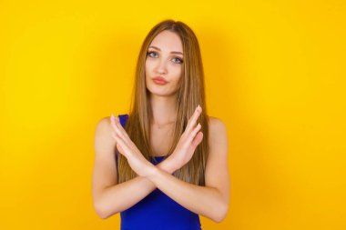 Genç, güzel, esmer, günlük kıyafetler giyen bir kız izole bir arka planın başında dikiliyor. Reddedilme ifadesi olumsuz işaret göndererek el ele tutuşuyor mu?.