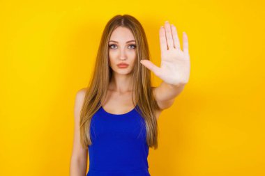 Genç, güzel, beyaz bir kadın avucunun içinde el hareketi yapıyor. Uyarı ifadesi 