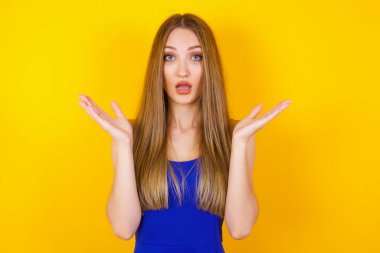 Sürpriz konsept. Şaşırmış güzel bir kızın portresi. İnanamamasına şaşırmış gibi görünüyor. Ağzın açık, yüzün yanında elleri var. Olumlu duygu yüz ifadesi vücut dili.