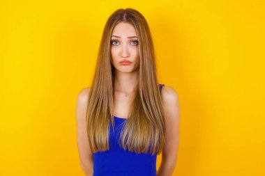 Üzgün, çaresiz, kederli, gözyaşları içinde, kederli bir kadının güzel yüzü. Acı ve depresyon çekiyor. Sarı arka planda, üzgün bir yüz ifadesi ve duygu konseptiyle izole edilmiş..