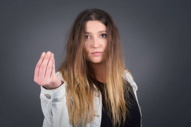 What the hell are you talking about. Shot of frustrated young European woman gesturing with raised hand doing Italian gesture, frowning, being displeased and confused with dumb question.