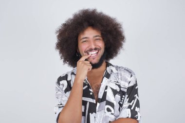 Düşünceli bir yüzü olan, kameraya bakan, elini yüzüne yakın tutan, parmağını ısıran hoş bir şey düşünen, gri duvara karşı poz veren hayalperest bir adam..