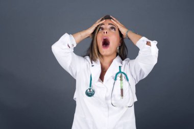 Korkunç, stres, şok. Kafasını tokalaştıran genç, duygusal, deli doktor kadın portresi. İnsani duygular, yüz ifadesi kavramı.