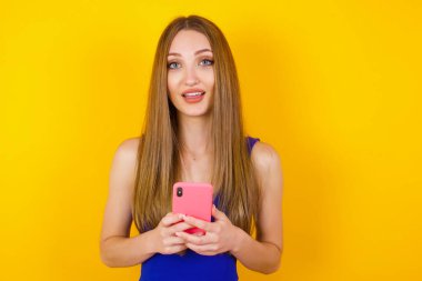 Dikkatini kameraya ver, akıllı telefondan uzak dur gülümse ve mutlu bir şekilde cep telefonunu tut, aynada selfie çek, arkadaşlarına yeni kıyafetler göster, alışveriş merkezinin soyunma odasında dur..