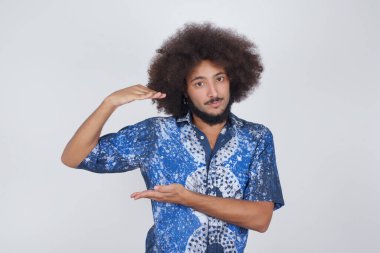  Avrupalı bir adam arka planda büyük ve büyük bir işaret, ölçü sembolü gösteren el hareketleriyle izole edilmiş. Kameraya bakıp gülümsüyor. Ölçüm konsepti.