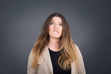 Güzel genç kadın gergin ve korkmuş dudaklar ısırıyor. Sabırsız bir ifadeyle kameraya bakıyor. Düşünceli. 