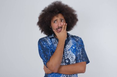 Endişe - yakışıklı bir adamın ellerini kapalı ve kapalı bir yerde durarak ağzını kapamasının kavramsal bir görüntüsü. Bir şeyden ya da birinin çivi yemesinden korktun mu?