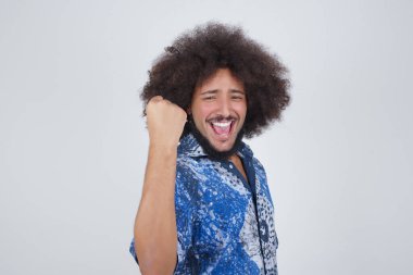 Sevinçten havalara uçmuş, sevinçli, sevinçli, iyi haberler almaktan memnun, mutluluktan hareketler yapan, yumruğunu sıkan ve kazanan bir jest yapan bir adam. Tepki konsepti.