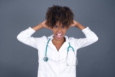 Heyecanlı Afrikalı Amerikalı doktor iyi haberler aldıktan sonra çığlık atıyor, ellerini başının üstünde tutuyor, inanamıyorum..