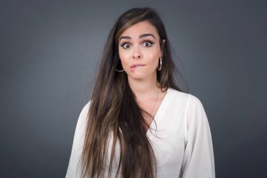 Güzel genç kadın gergin ve korkmuş dudaklar ısırıyor. Sabırsız bir ifadeyle kameraya bakıyor. Düşünceli. 