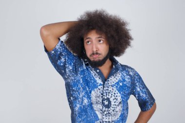 Tüh, ne yaptım ben? Korkmuş ve pişmanlık dolu ifadesiyle el ele tutuşan yakışıklı bir adam. Gri arka planda dikilen günlük giysiler giyiyor..