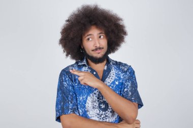 Kamerada poz veren genç bir adamın portresi hileli bir bakış ve yana hareket. Erkek tasarımcı güzel ürünleri işaret parmağıyla sunuyor. Hareket kavramı.