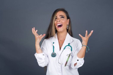 Çığlık, nefret, öfke. Ağlayan öfkeli doktor kadın stüdyoda çığlık atıyor. Duygusal, genç yüz. İnsani duygular, yüz ifadesi kavramı.