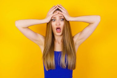 Korkunç, stres, şok. Kafasını tokalaştıran genç, duygusal bir kadının portresi. İnsani duygular, yüz ifadesi kavramı. Moda renkleri. Ön görünüm