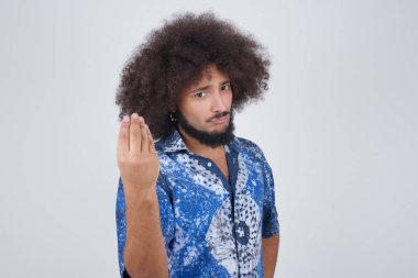 What the hell are you talking about. Shot of frustrated young European man gesturing with raised hand doing Italian gesture, frowning, being displeased and confused with dumb question.