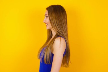 Sağlıklı ve saf cilde sahip gülümseyen bir kadının profili derin bir ifadeye sahiptir. Açık havada yürümeye hazırdır.