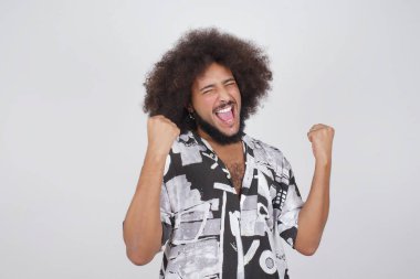 Kafkasyalı adam başarısını ve zaferini sevinçle kutluyor ve yumruklarını zevkle sıkıyor. Hedeflerine ve hedeflerine ulaşmaktan mutlu olan şanslı adam. Olumlu duygular, duygular.