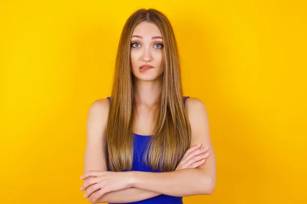 Isolated portrait of stylish young European woman bitting her lip and looking worried