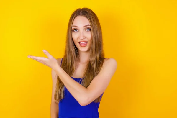 Mujer Positiva Muestra Algo Espacio Blanco Con Mano Abierta Concepto —  Fotos de Stock