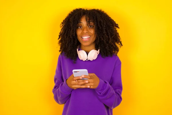 Donna Afroamericana Sfondo Giallo Sorridente Mentre Tiene Telefono Emozioni Gesti — Foto Stock