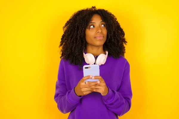 Africká Američanka Něco Dívá Drží Telefon Obou Rukou Emoce Gesta — Stock fotografie