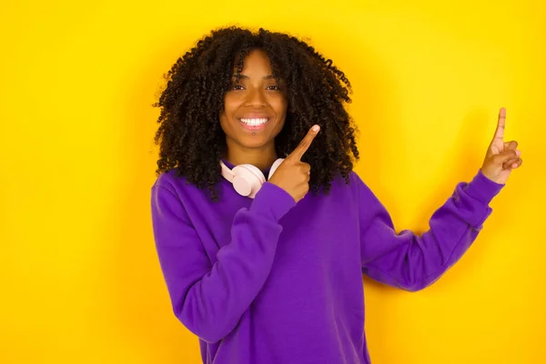 Afro Amerikaanse Vrouw Wijst Omhoog Met Beide Handen Gele Achtergrond — Stockfoto