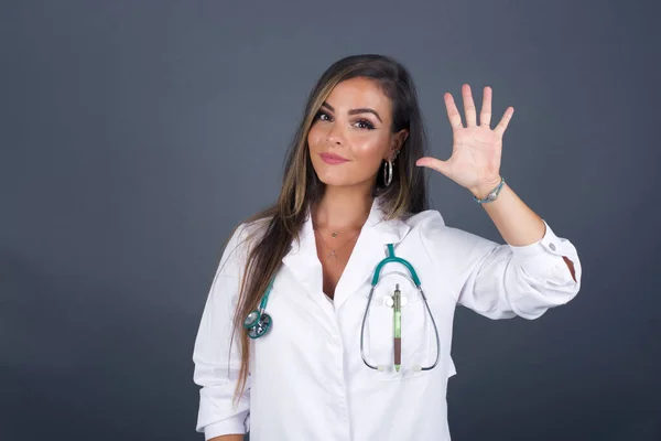 Joven Doctora Pie Contra Pared Gris Mostrando Señalando Hacia Arriba —  Fotos de Stock