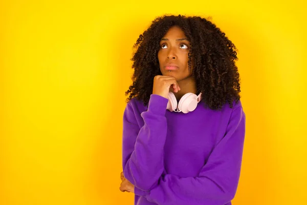 穿着紫色针织毛衣的年轻而美丽的非洲裔美国女人 背景是黄色的 — 图库照片