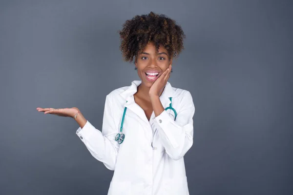 Vreugdevolle Afro Amerikaanse Doktersvrouw Demonstreert Iets Een Hand Haar Hoofd — Stockfoto