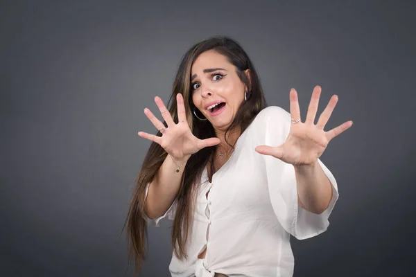 Dissatisfied female model frowns face, has disgusting expression, shows tongue, expresses non compliance, irritated with somebody, rejects do something. People and negative facial expressions