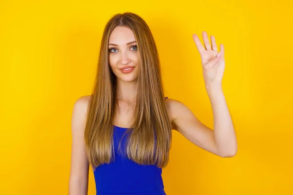 Jonge Vrouw Staande Tegen Gele Muur Tonen Wijzen Met Vingers — Stockfoto