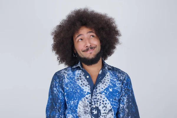 Gizemli bir gülümsemeyle yukarı bakan gizemli bir adamın portresi. Yakışıklı, gülümseyen adam gri duvara bakıyor..