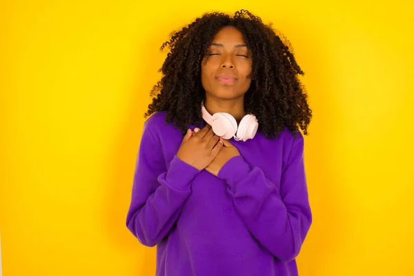 年轻美丽的非洲裔美国妇女 身穿紫色针织毛衣 背景为黄色 — 图库照片