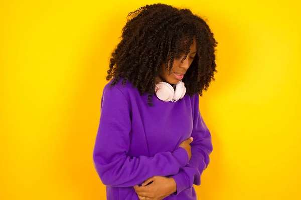 African American Female Holds Her Stomach Pain Yellow Background Emotions — Stock Photo, Image