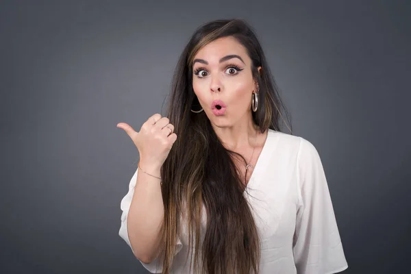 Horizontal Shot Pretty Young Joyful Shocked Woman Points Thumb Away — Stock Photo, Image