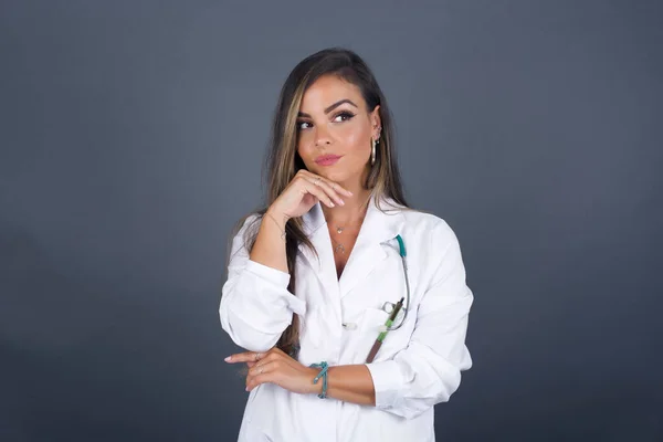 Mujer Doctora Soñadora Con Expresión Agradable Vistiendo Uniforme Médico Mira —  Fotos de Stock