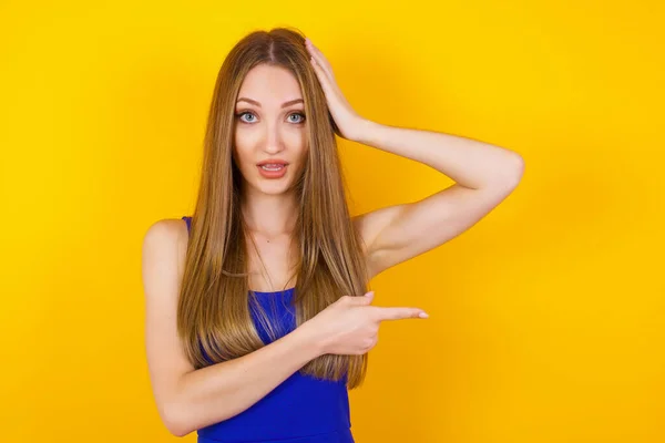 Joyful Pretty Young Woman Demonstrates Something One Hand Her Head — Stock Photo, Image