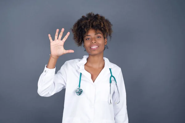 Afroamerikanische Ärztin Steht Vor Grauer Wand Und Zeigt Mit Finger — Stockfoto