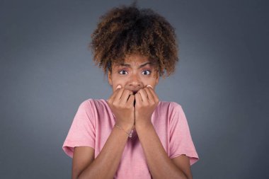 Endişe, ellerini kullanarak ağzını kapatan genç ve güzel bir Afro-Amerikan kadının kavramsal görüntüsü. 