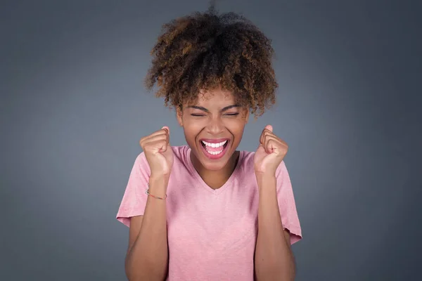 stock image african american woman rejoicing her success and victory clenching her fists with joy. Positive emotions, feelings.