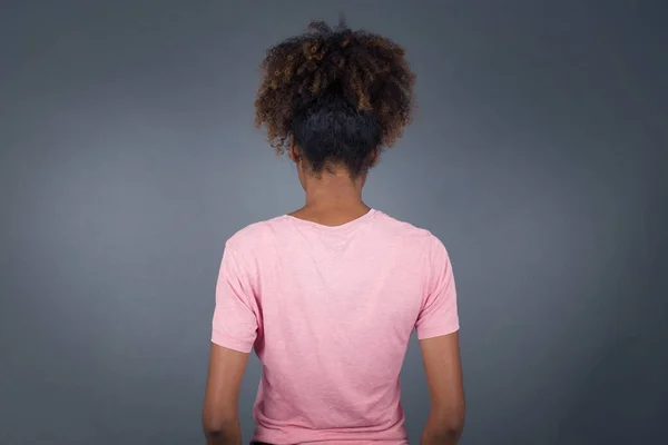 灰色の壁に立っている若い美しいアフリカ系アメリカ人の女性の背後にある景色 スタジオショット — ストック写真