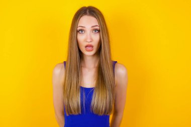 Çekici genç bir kadın ağzı açık ve çenesi düşük, sersemlemiş ve şok olmuş görünüyor.