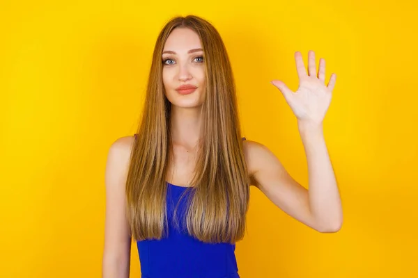 Jonge Vrouw Staande Tegen Grijze Muur Tonen Wijzen Met Vingers — Stockfoto