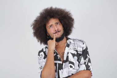 Kaşlarını kaldırmış sorunlu bir adam gri arka planda izole edilmiş, pişman görünüyor..