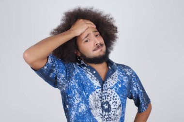 Yakışıklı bir adam, korkmuş ve pişmanlık dolu bir ifadeyle alnından el ele tutuşuyor. Günlük giysiler giyiyor.