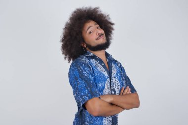 Yakışıklı, kendine güvenen, neşeli, kolları çapraz gri duvarlı genç adamın fotoğrafı.