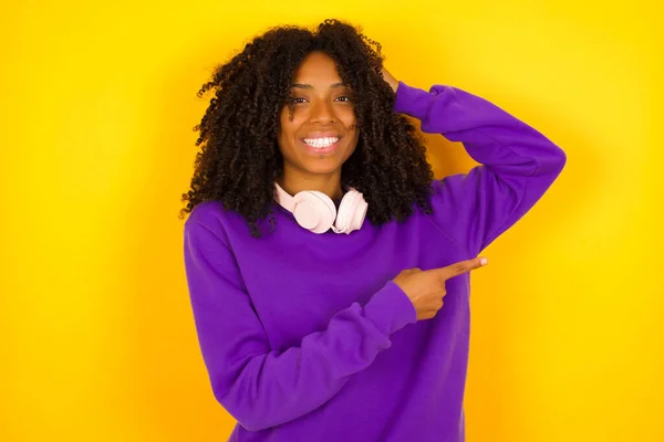 Mujer Afroamericana Señala Derecha Sobre Fondo Amarillo Concepto Emociones Gestos —  Fotos de Stock